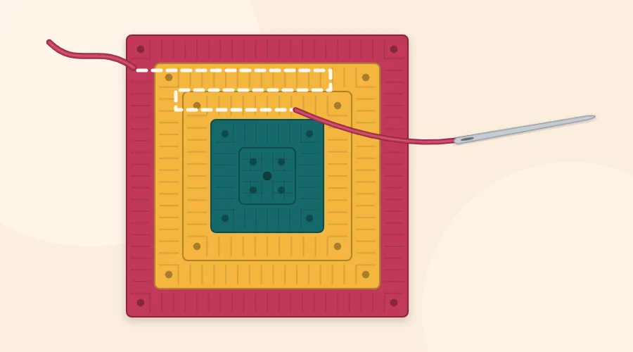 Yarn needle following a zigzag path through the base of the stitches on the back of a granny square